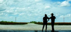 Female and male coworkers looking out over a field together.