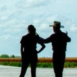 Coworkers looking out over crops.