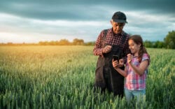 Grandad and granddaughter in a field.