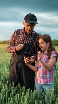Grandad and granddaughter in a field.