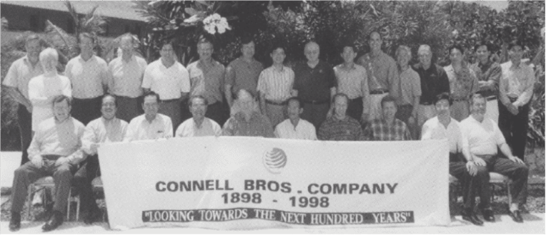 Group of Connell employees with a banner, Connell Bros. Company 1898-1998. "Looking towards the next hundred years.