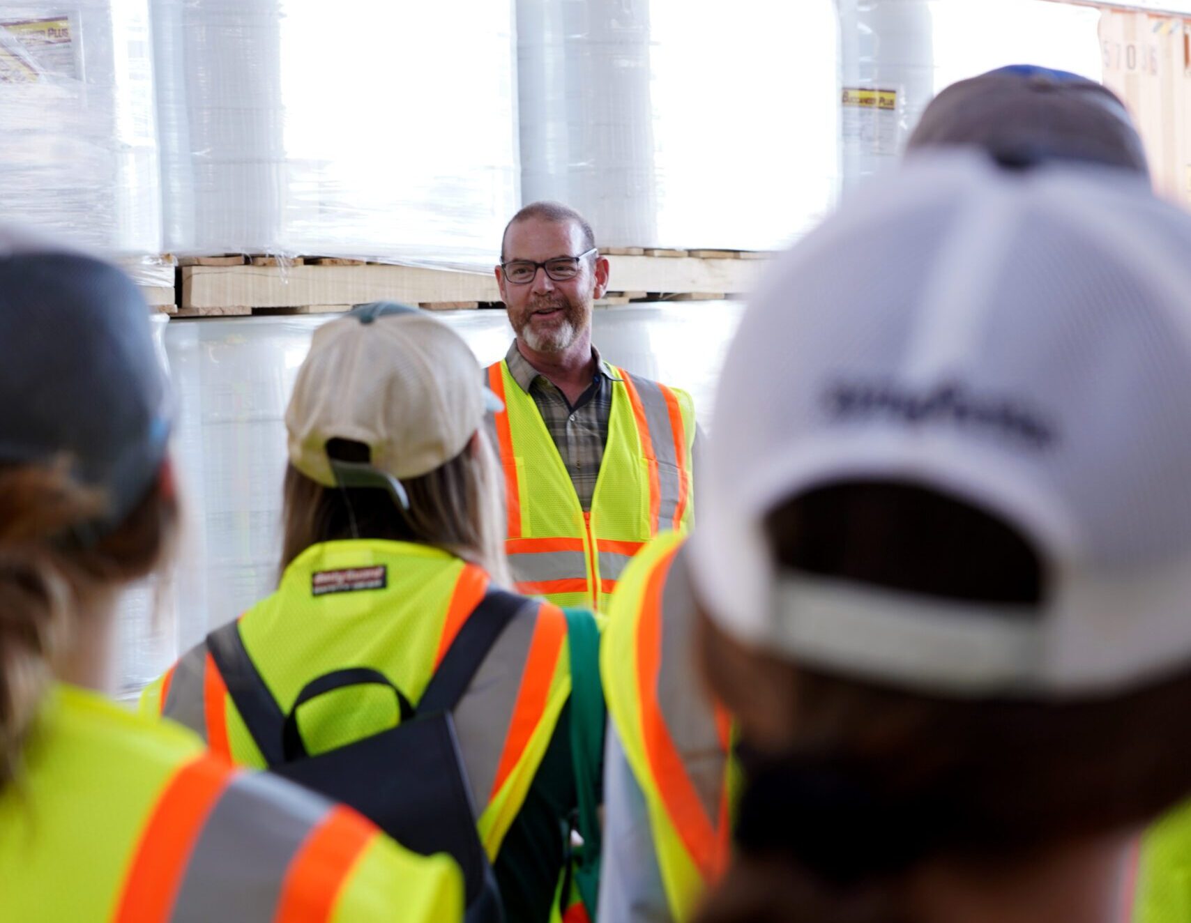 Supervisor talking to the team, all wearing saftey jackets