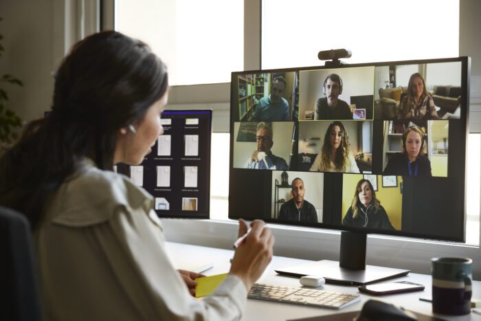 Businesswoman discussing with colleagues during video conference. Male and female entrepreneurs attending online meeting. They are planning business strategy.