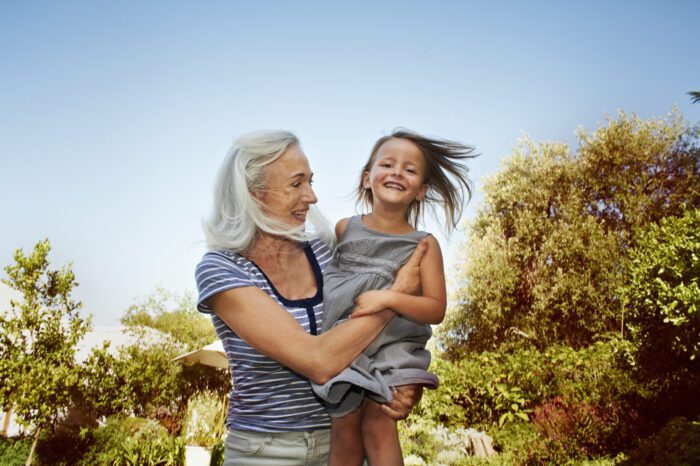 Mature lady holding up her granddaughter and laughing together