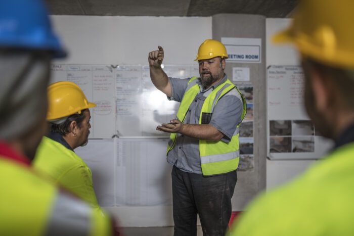 Construction workers on building site talking to the team